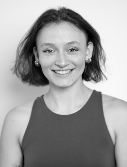 Frontalaufnahme von Emmi Cholewa mit schulterlangem Haar, lächelnd, in ärmellosem Oberteil, Schwarz-Weiß-Bild