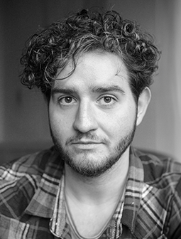 Porträt von Oliver Kleppel mit lockigem Haar, direkter Blick in die Kamera, Schwarz-Weiß-Fotografie
