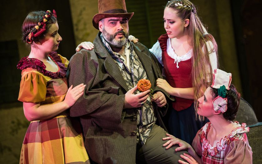 Belles Vater hält mit sorgenvoller Miene die Rose, umgeben von Belle und ihren Schwesternn.