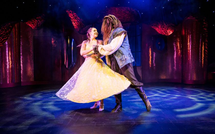 Belle und Biest tanzen im Ballsaal, mit funkelnden Lichtern und märchenhafter Kulisse