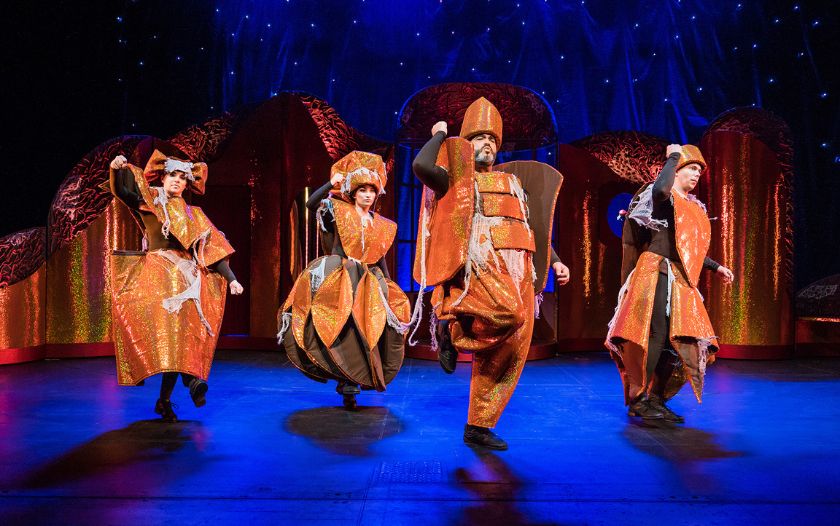  Vier Darsteller als verzauberte Schlossbewohner tanzen in fantasievollen Kostümen auf der Bühne