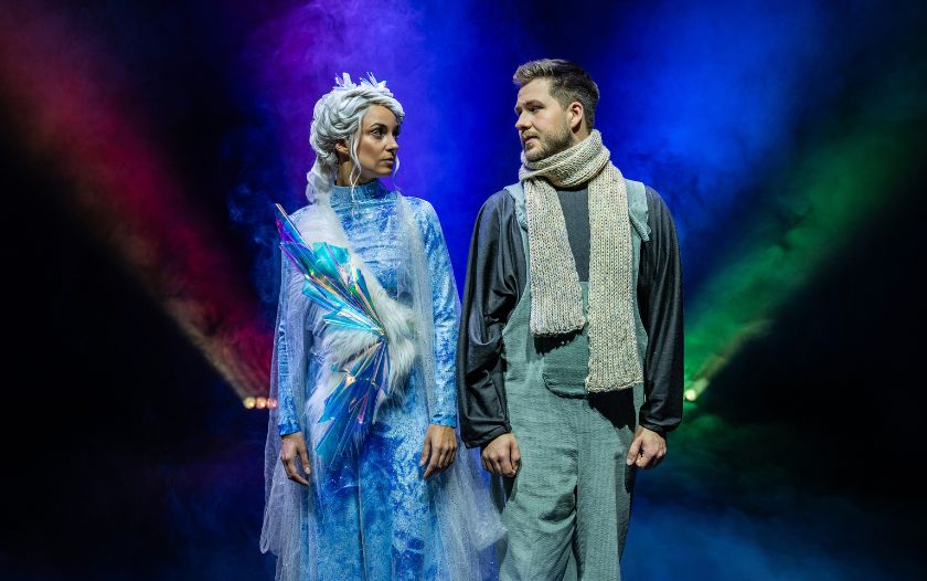 Schneekönigin und Kai stehen sich ernst gegenüber. Im Hintergrund ist ein blaues Lichtspiel zu sehen. 