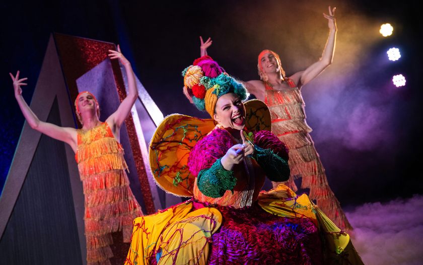 Die farbenfrohe Frida während ihres Auftritts mit zwei Tänzern in Schneekönigin – das Musical von Theater Liberi