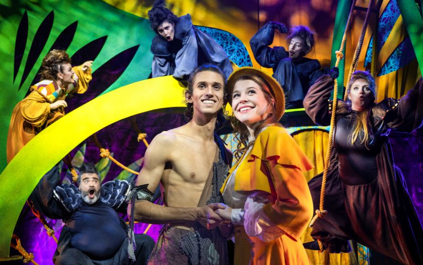 Tarzan und Jane stehen verliebt nebeneinander, während sie von fantasievoll kostümierten Tierfiguren in einem bunten Dschungelambiente umgeben sind.