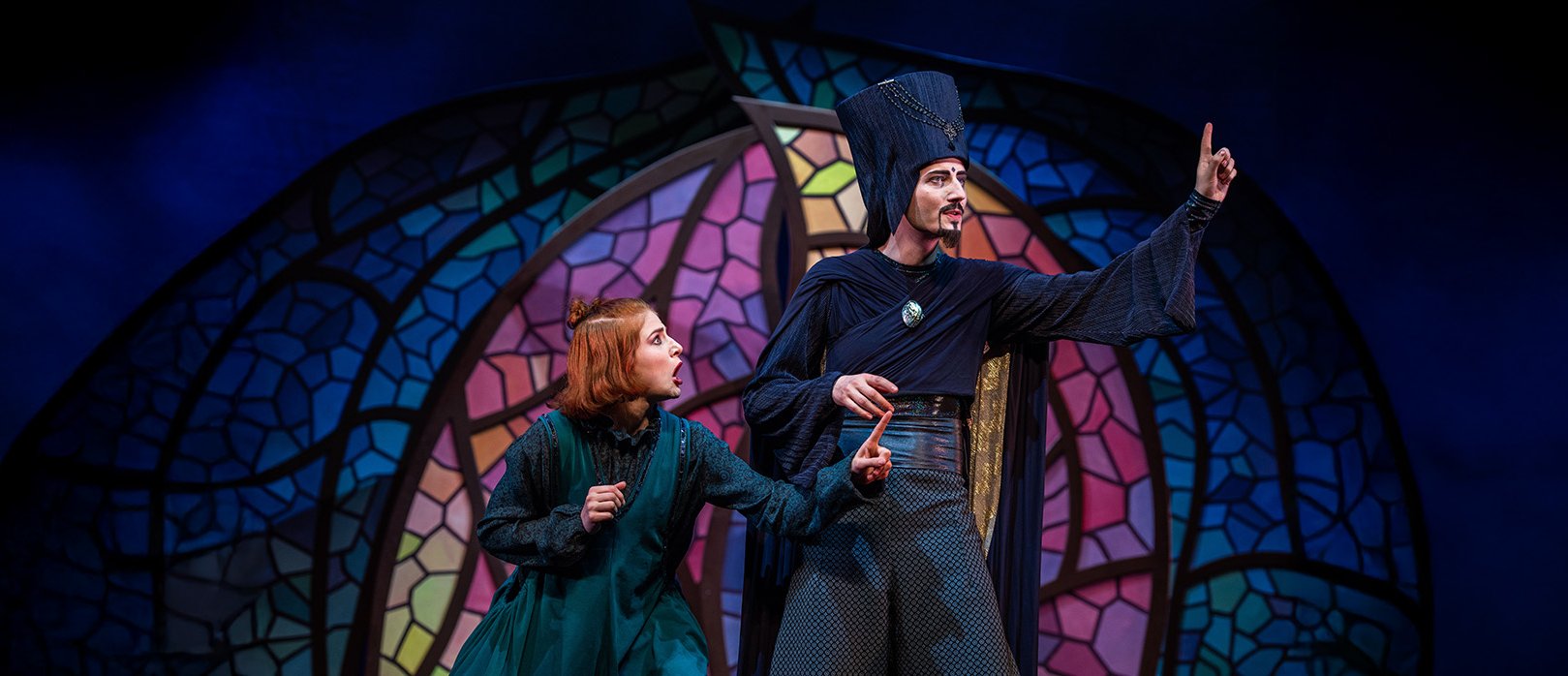 Zwei Darsteller auf der Bühne in einer spannenden Szene aus „Aladin – das Musical“ mit bunter Kulisse im Hintergrund